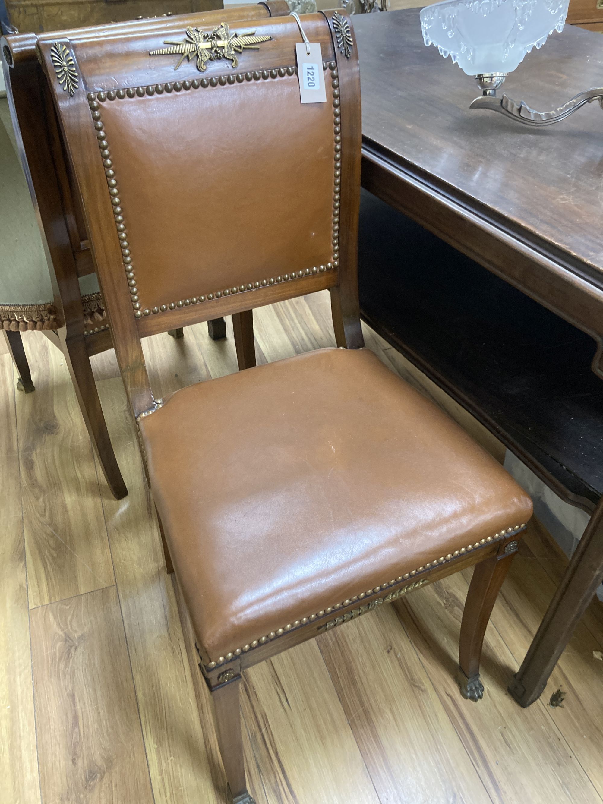 A set of six Empire style brass mounted mahogany dining chairs with tan leather upholstery